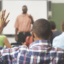 boy raising hand in class