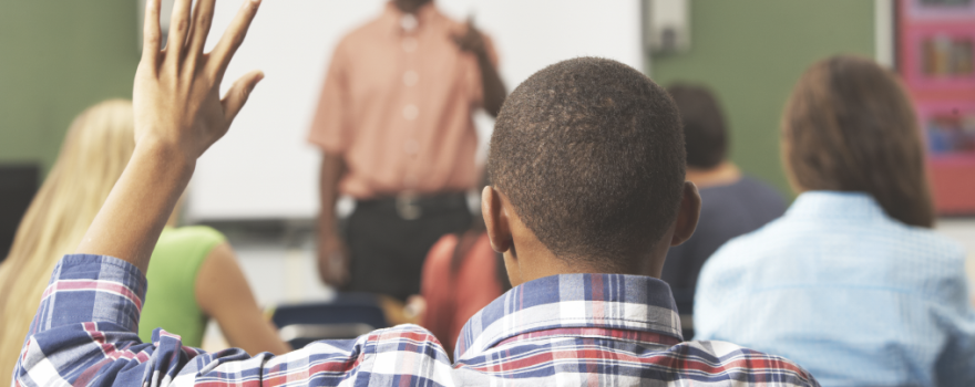 boy raising hand in class