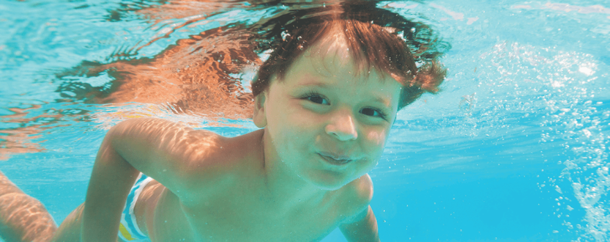 kid swimming under water in pool