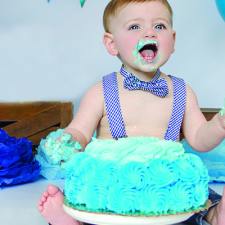 toddler eating cake with his hands