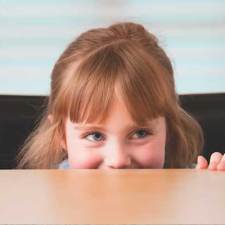 girl peeking over the table