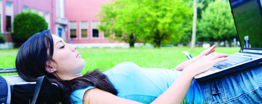 female college student on laptop outdoors