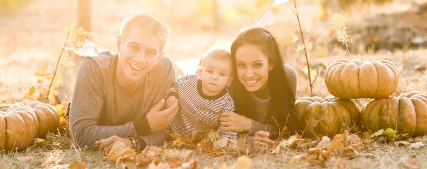 family on ground with pumpkins