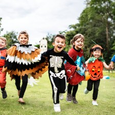 kids in halloween costumes running in a field