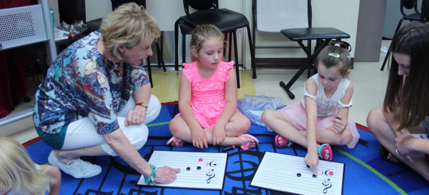 young girls learning to read music