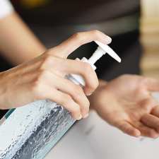 woman using hand sanitizer