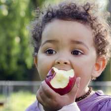 Little boy eating an apple