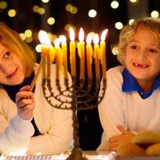 kid lighting menorah