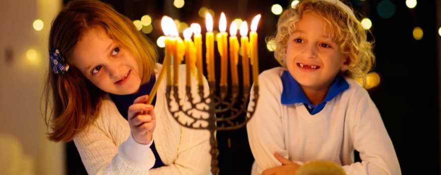 kid lighting menorah