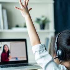 Girl raising hand during remote learning