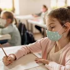 School girl takes test with Covid mask on