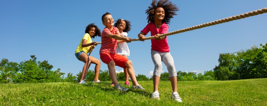 Kids playing tug-of-war in grass