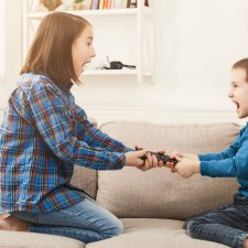 Boy and girl fighting over remote