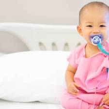 Baby in hospital bed with pacifier