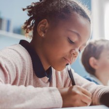 young girl writing in classroom