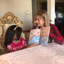 woman reading a book to little girl