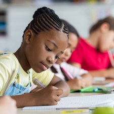 children writing in a classroom