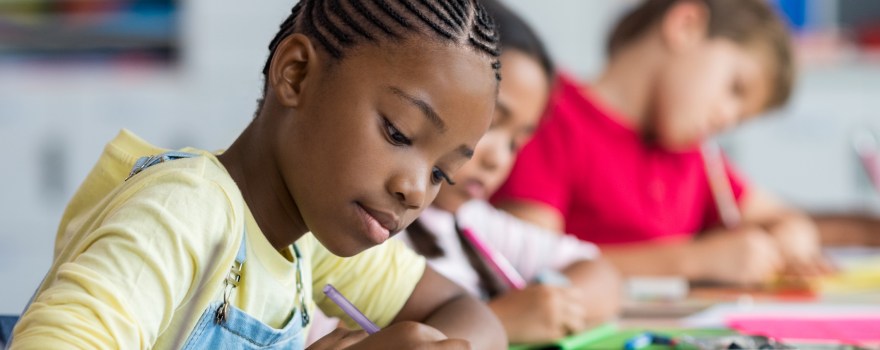 children writing in a classroom