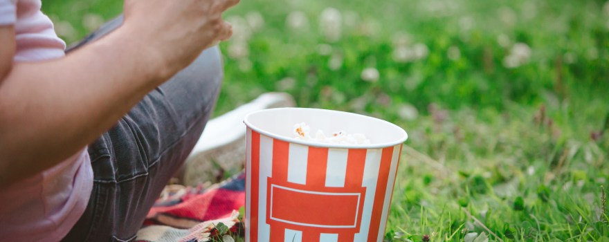 person sitting on lawn eating popcorn