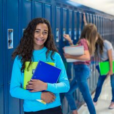 teen at lockers in a school