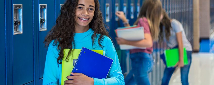 teen at lockers in a school