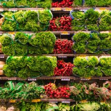 Groceries, specifically produce, on shelves in a store.