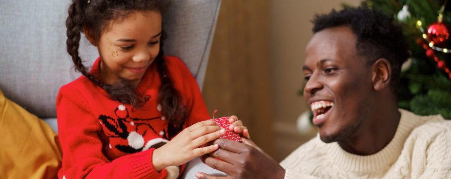 Father giving his daughter a holiday gift.