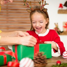 Child wrapping holiday present.