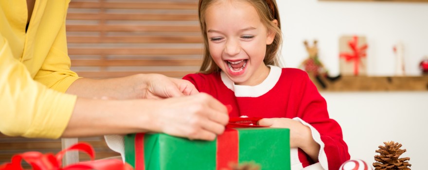 Child wrapping holiday present.