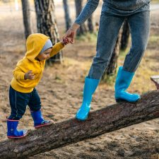 Toddler playing outside with parent.