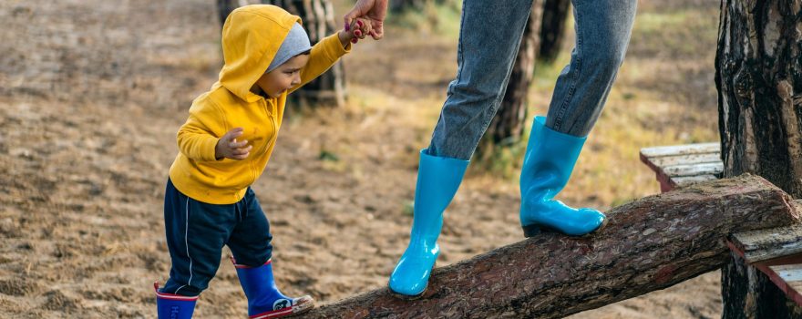 Toddler playing outside with parent.