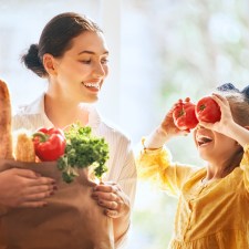 Mother and daughter holding groceries.