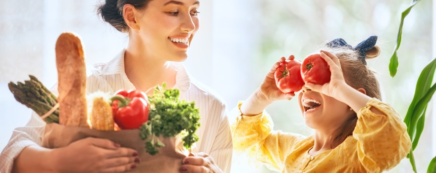 Mother and daughter holding groceries.