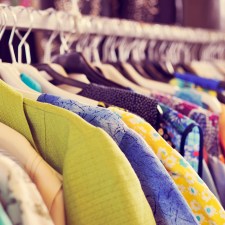 Clothes hanging on a rack at a market, similar to what can be found at an artists market on Staten Island