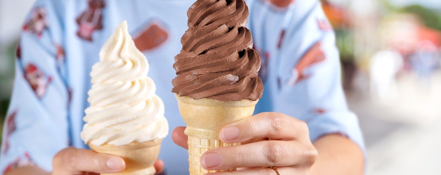 a vanilla soft serve ice cream cone and a chocolate soft serve ice cream cone from Carvel, which is offering deals for National Soft Serve Day.