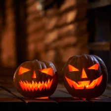 Two glowing jack-o’-lantern pumpkins at the entrance to a house, similar to decorations that can be part of haunted houses on Staten Island