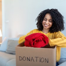 woman packing clothes into a box. Picture is for an article on where to donate clothes on Staten Island