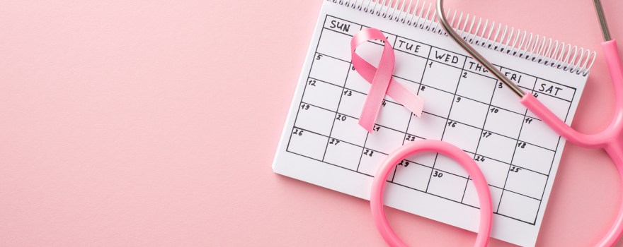 pink ribbon that raises awareness about breast cancer, with calendar and stethoscope, which highlights the importance of prioritizing breast health